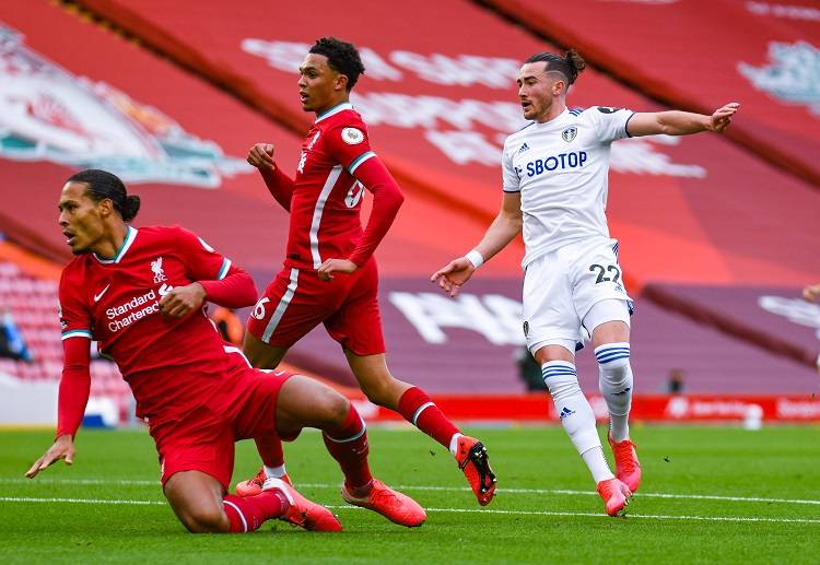 Liverpool players trying to stop Premier League opponent Leeds United during their clash